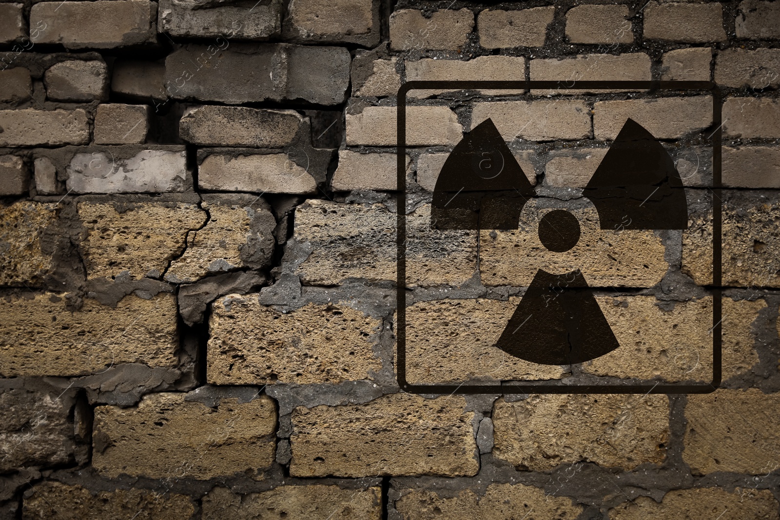 Image of Radioactive sign on old brick wall. Hazard symbol