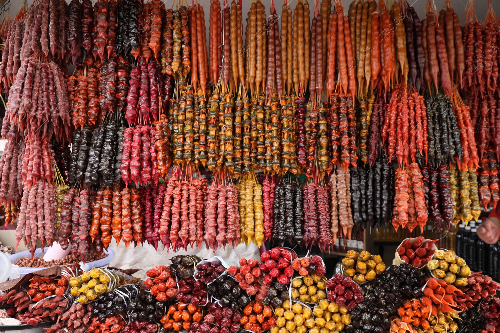 Photo of Bunches of different delicious churchkhelas at market