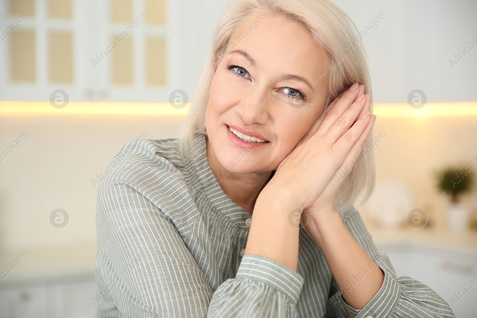 Photo of Portrait of beautiful mature woman in kitchen