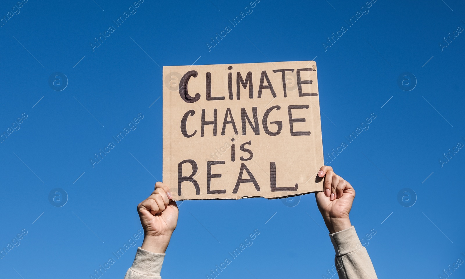 Photo of Young woman with poster protesting against climate change outdoors, closeup