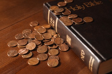 Photo of Donate and give concept. Coins and Bible on wooden table