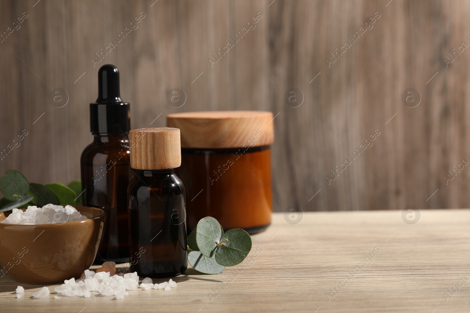 Photo of Composition with spa products and eucalyptus leaves on wooden table, space for text