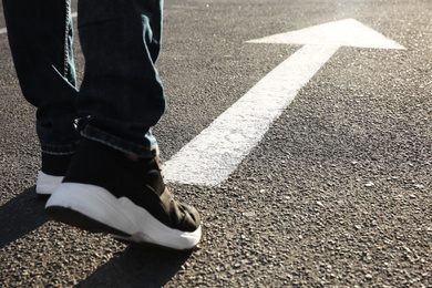 Photo of Man going along road with arrow marking, closeup