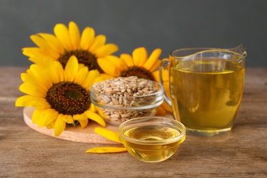 Photo of Sunflowers, oil and seeds on wooden table