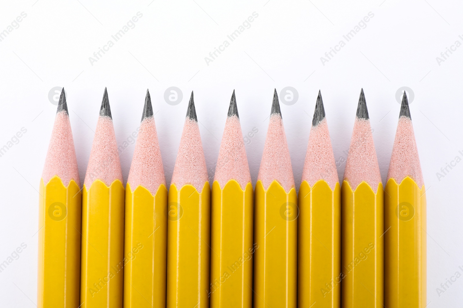 Photo of Many sharp graphite pencils on white background, top view