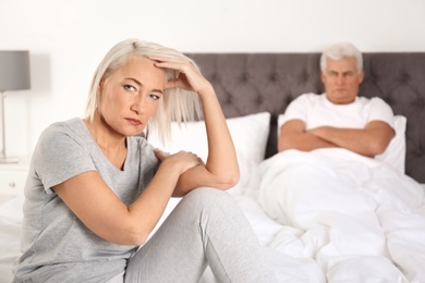 Photo of Senior woman having conflict with her husband in bedroom. Relationship problems