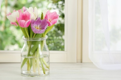 Beautiful fresh tulips on window sill indoors. Spring flowers