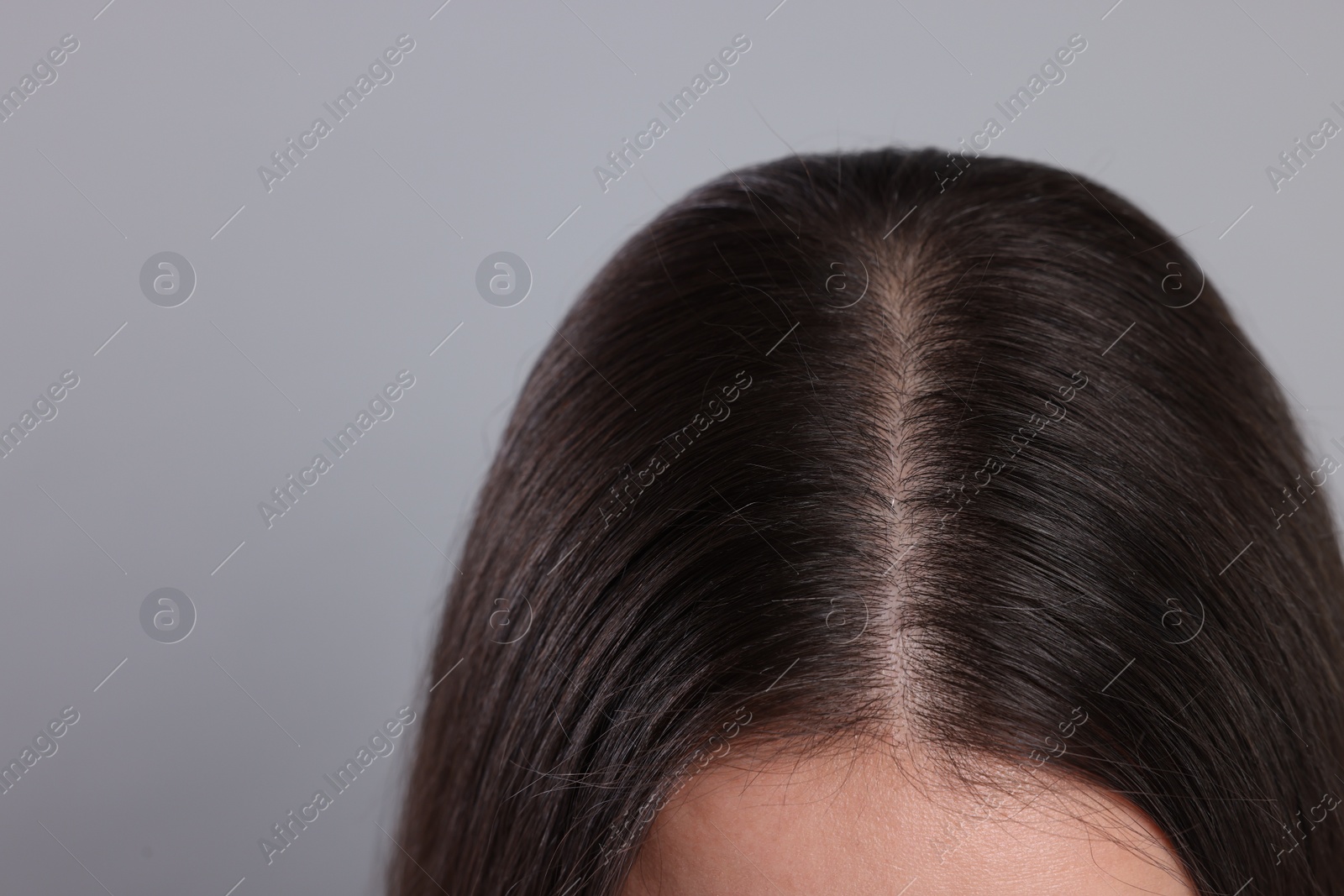 Photo of Woman with healthy hair on grey background, closeup. Space for text