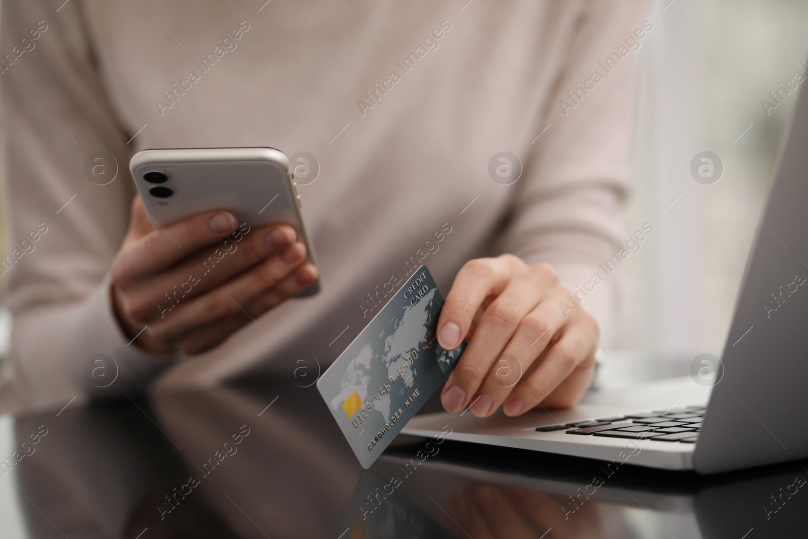 Photo of Woman with credit card using laptop and smartphone for online shopping, closeup