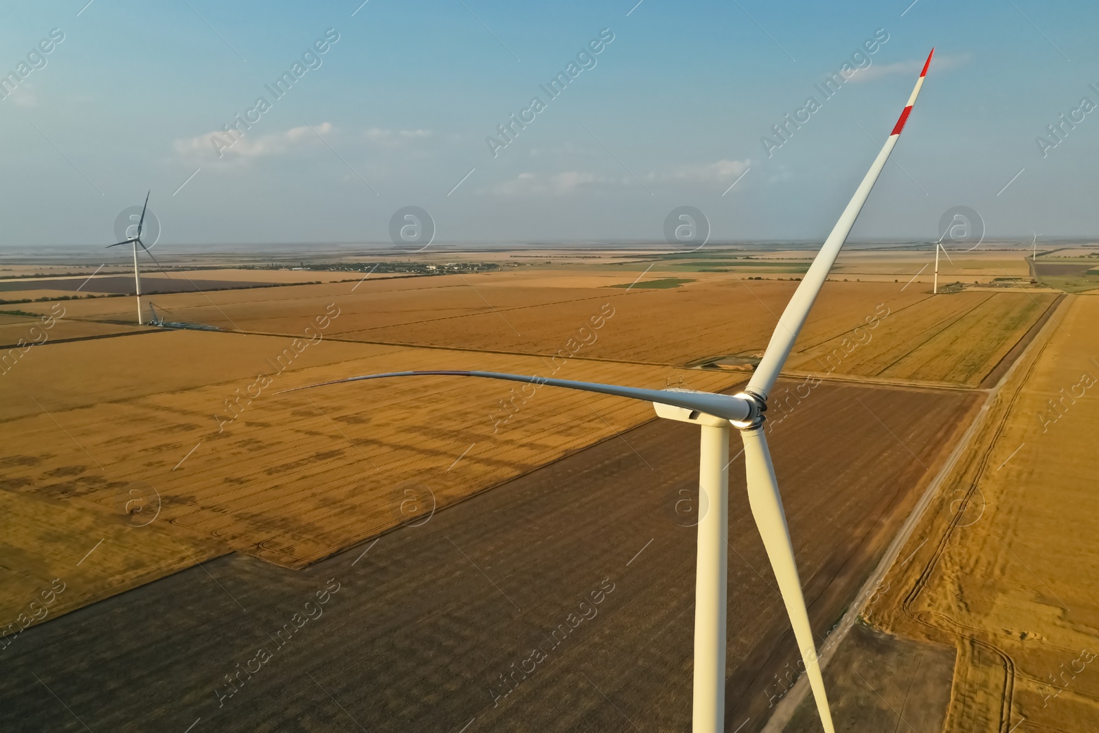 Image of Modern wind turbine under blue sky. Alternative energy source