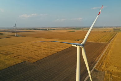Image of Modern wind turbine under blue sky. Alternative energy source