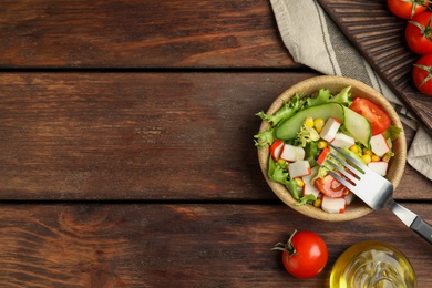 Photo of Crab stick salad with tomatoes and lettuce on wooden table, flat lay. Space for text