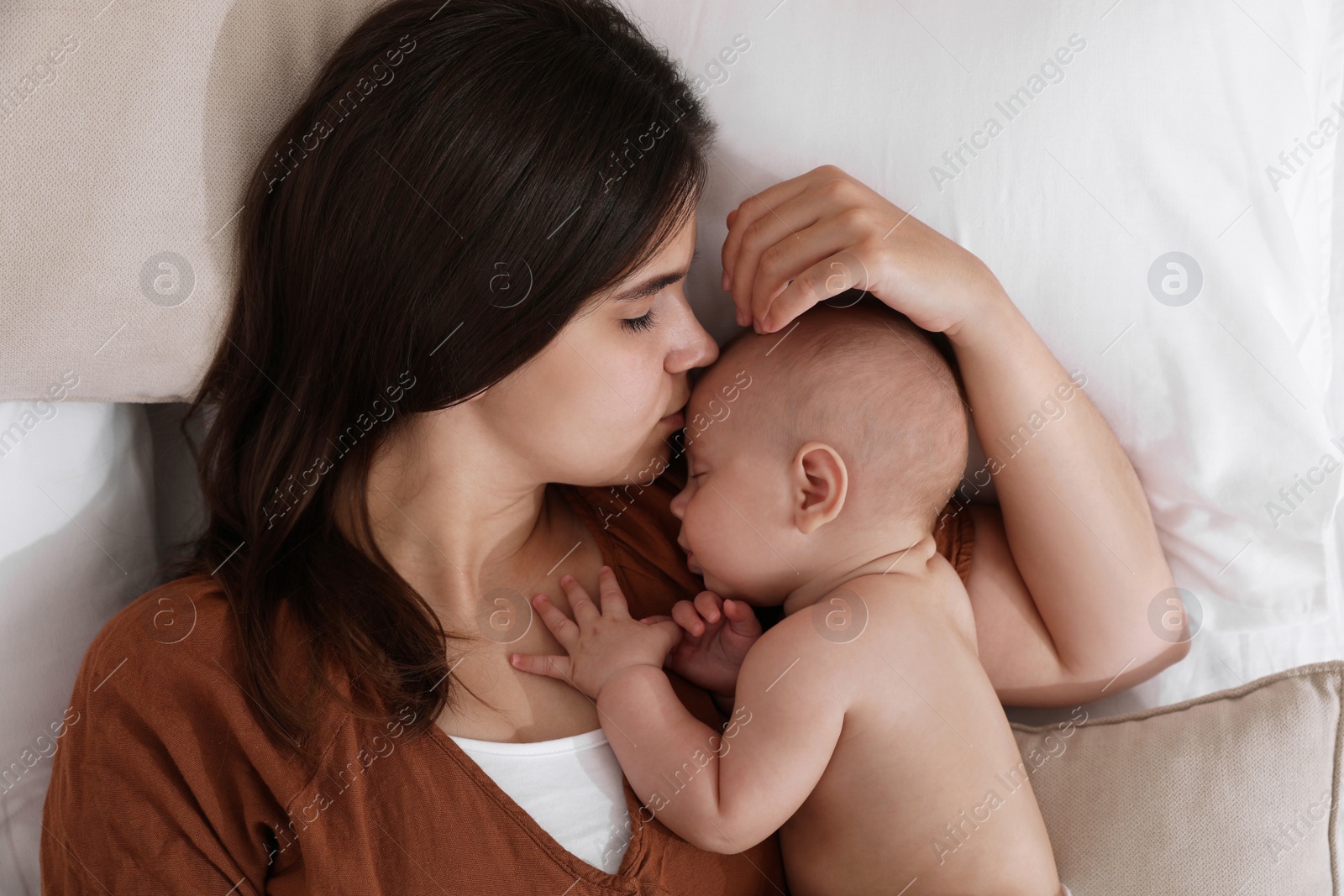 Photo of Mother with her cute baby sleeping on bed, top view