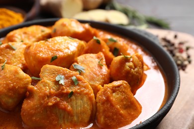 Photo of Delicious chicken curry in pan on table, closeup