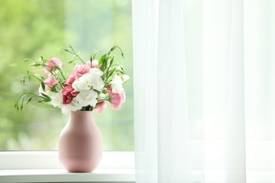 Photo of Vase with beautiful flowers on window sill, space for text