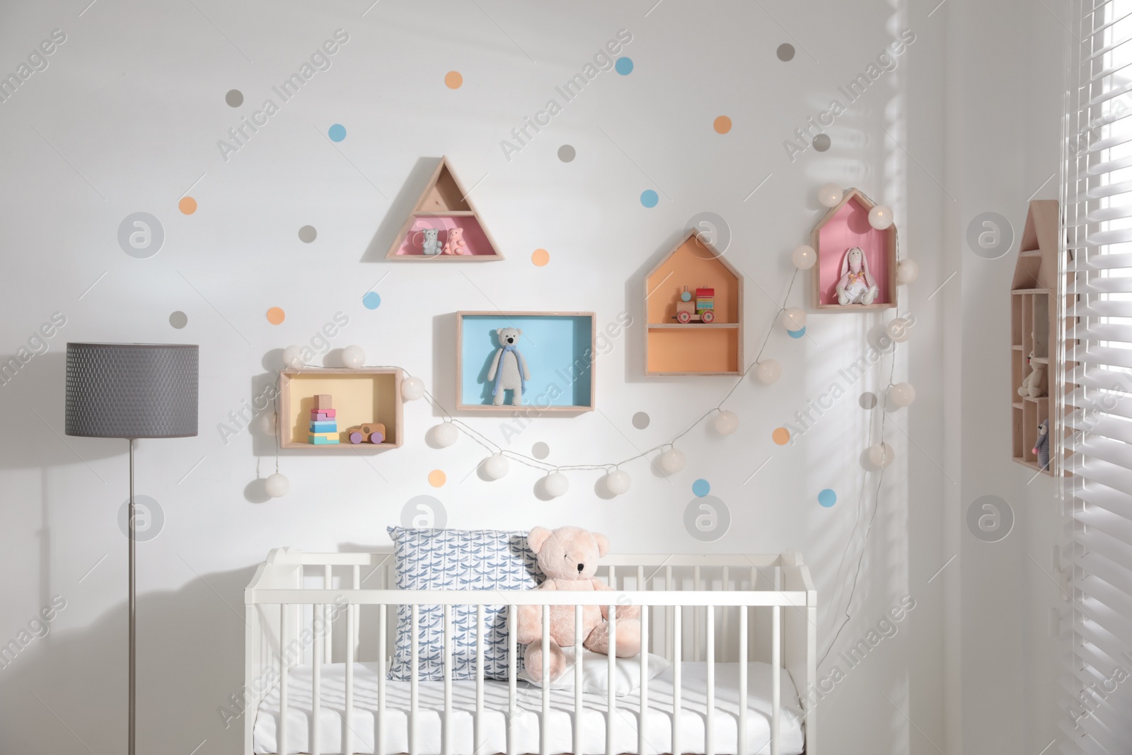 Photo of Cute children's room with house shaped shelves and crib. Interior design