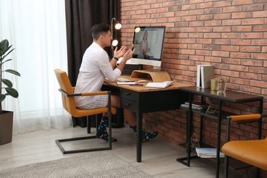 Photo of Businessman in shirt and underwear having video call on computer at home office