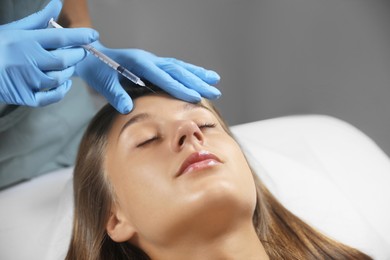 Beautiful woman getting facial injection in salon