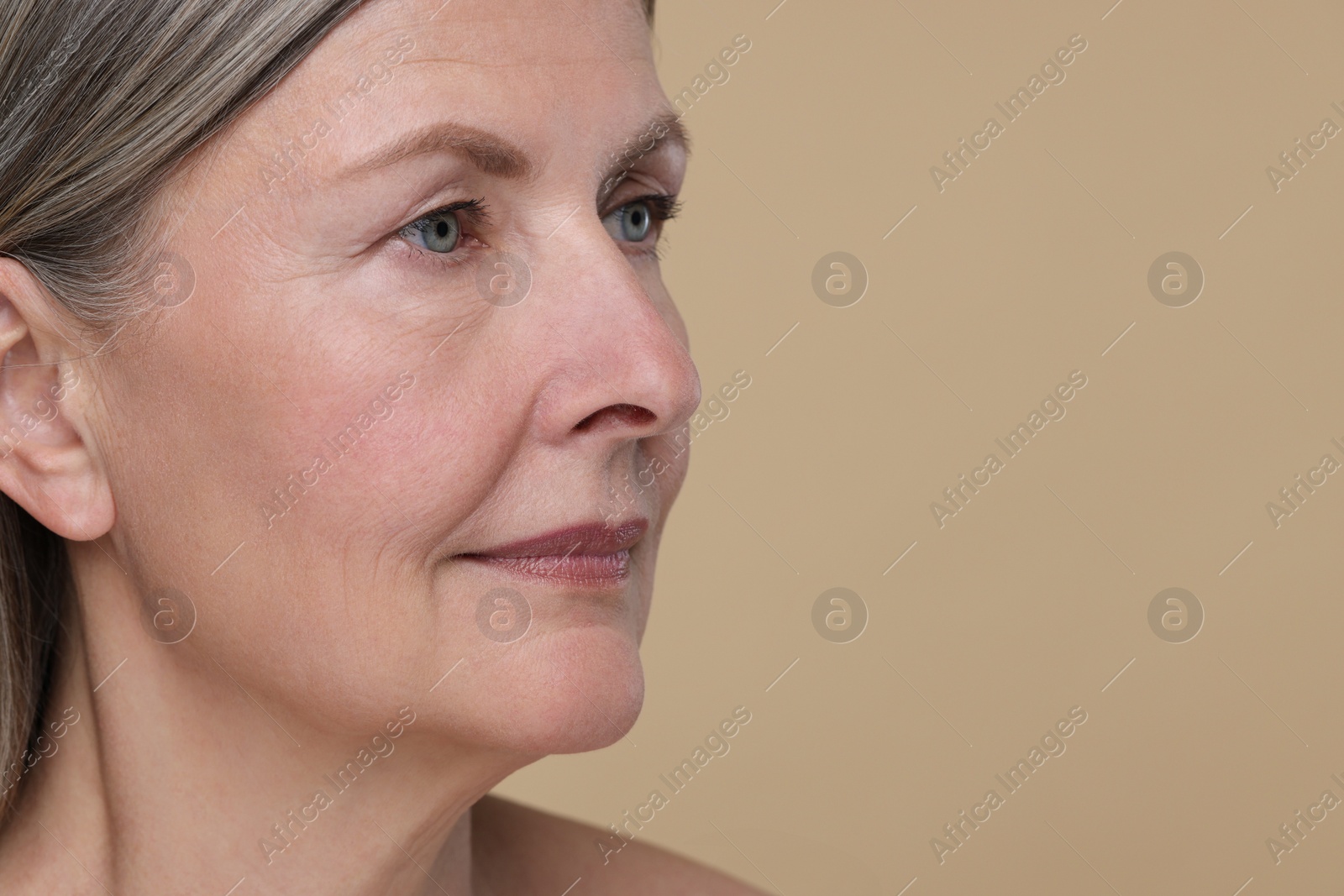 Photo of Portrait of senior woman with aging skin on beige background, space for text. Rejuvenation treatment