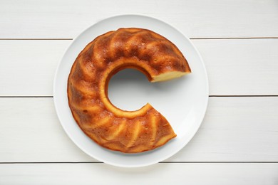 Photo of Delicious homemade yogurt cake on white wooden table, top view