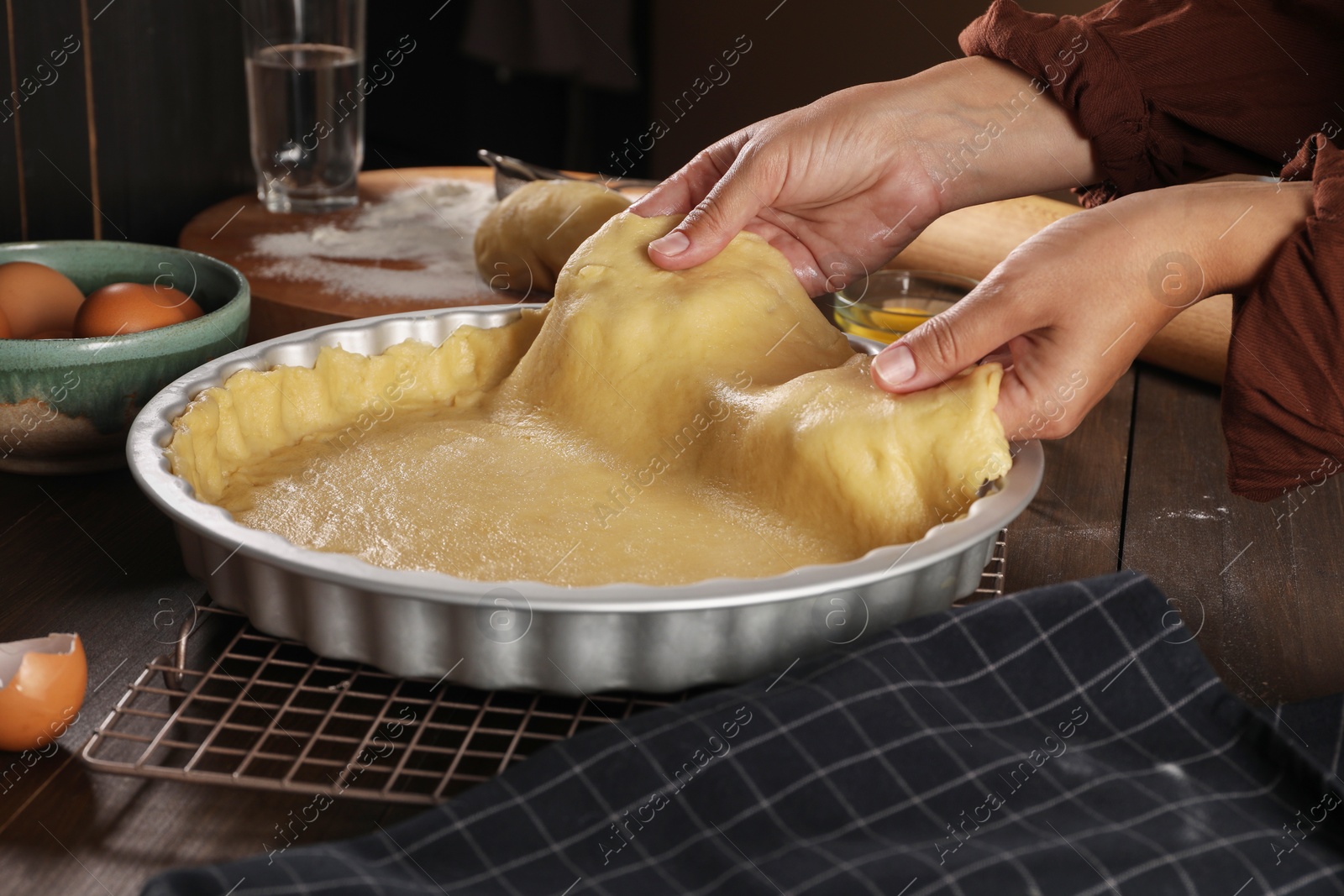 Photo of Woman making quiche at wooden table, closeup