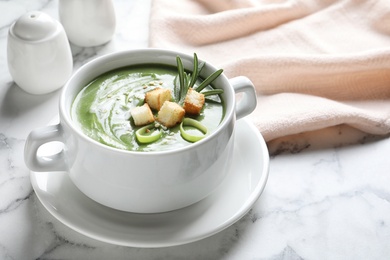 Photo of Fresh vegetable detox soup with croutons in dish on table. Space for text