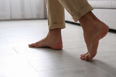 Man walking barefoot at home, closeup. Floor heating concept