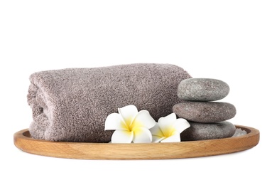 Photo of Wooden tray with towel, spa stones and flowers isolated on white