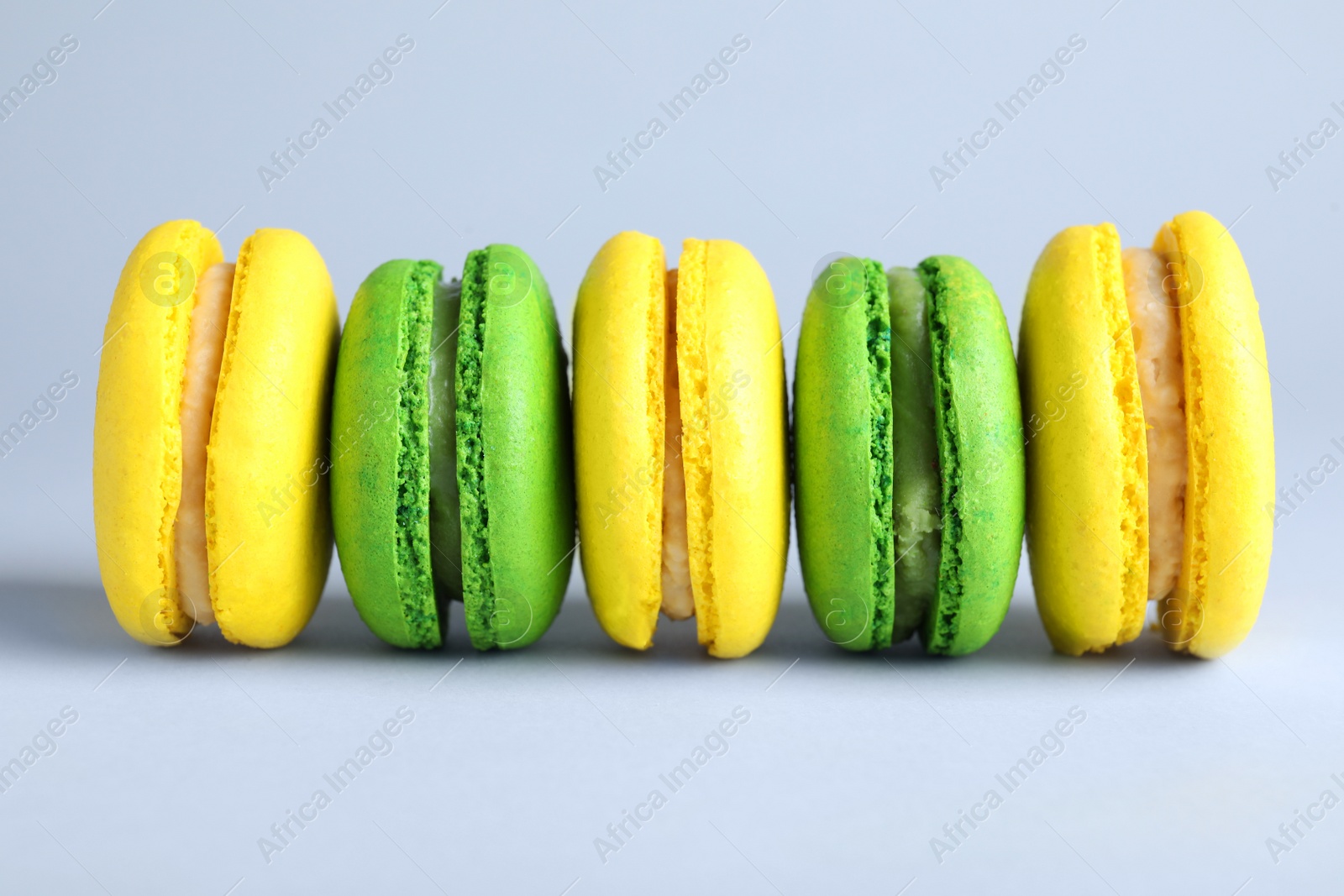 Photo of Delicious colorful macarons on light grey background