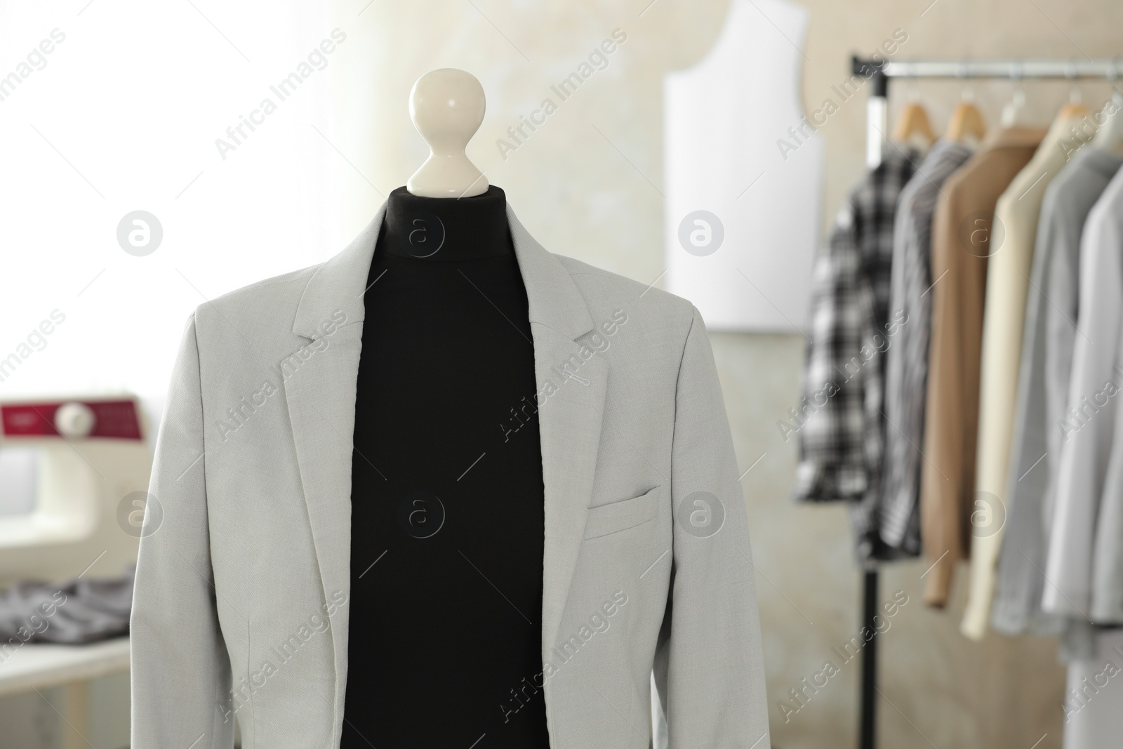 Photo of Mannequin with stylish jacket in tailor shop, space for text