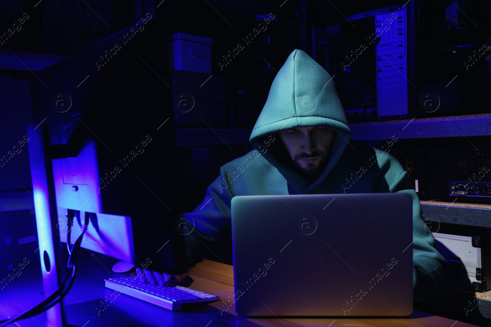 Photo of Hacker working with computers in dark room. Cyber attack