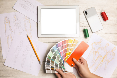 Photo of Fashion designer with color palette at workplace, top view