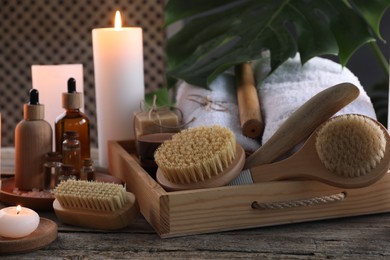 Composition with different spa products and burning candles on wooden table