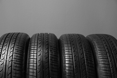 Car tires on grey background, closeup