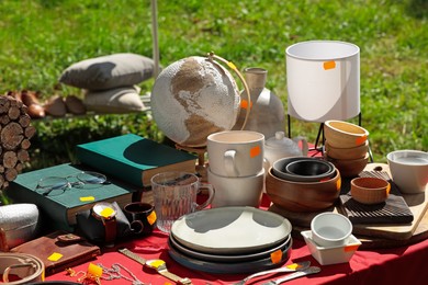 Many different items on table outdoors. Garage sale