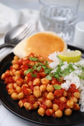 Photo of Delicious chickpea curry with rice on table, closeup