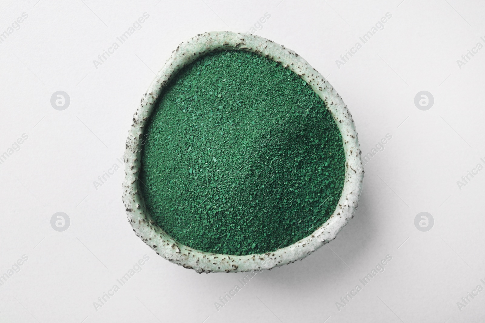 Photo of Bowl of spirulina algae powder isolated on white, top view