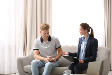 Female insurance agent working with young man in office