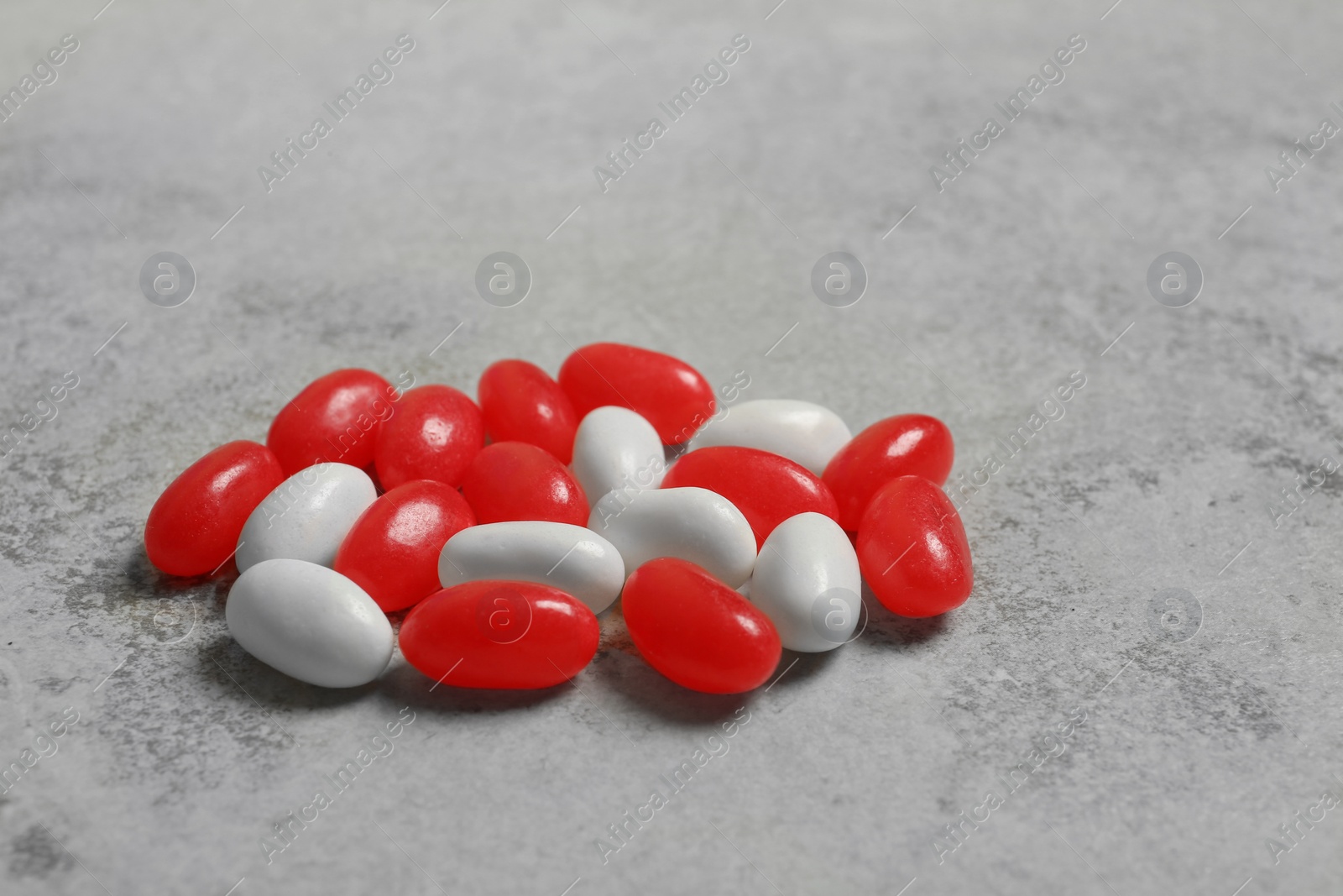 Photo of Delicious bright jelly beans on stone background, closeup