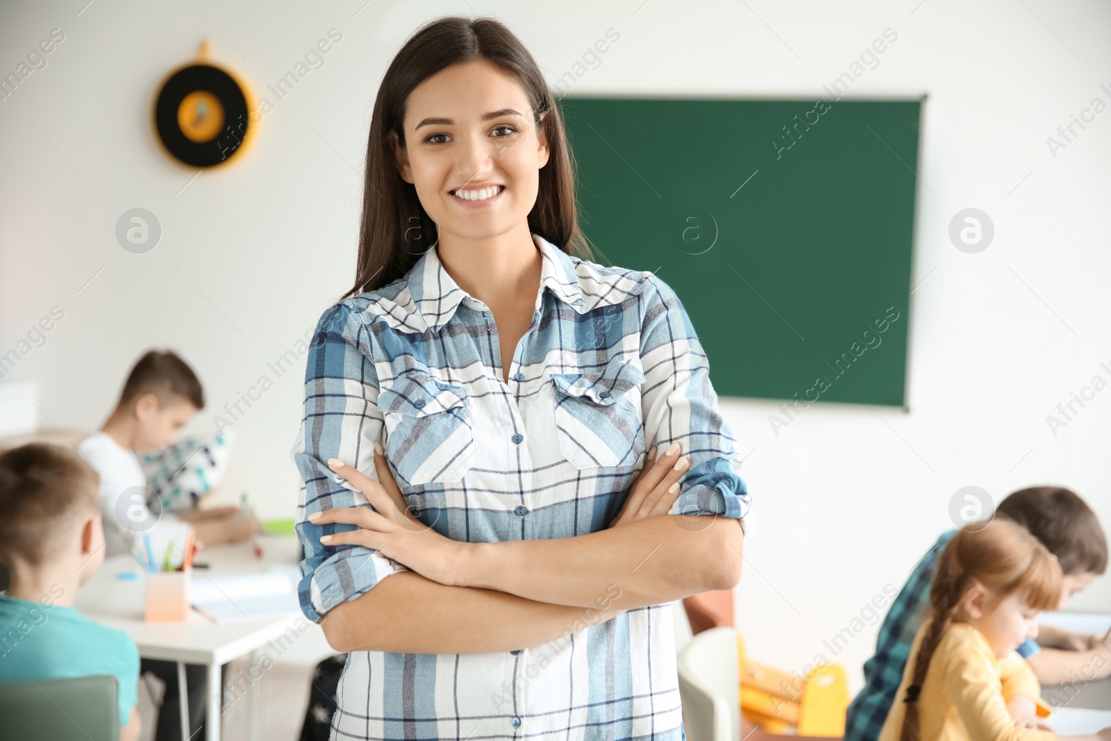 Photo of Young teacher in classroom at school