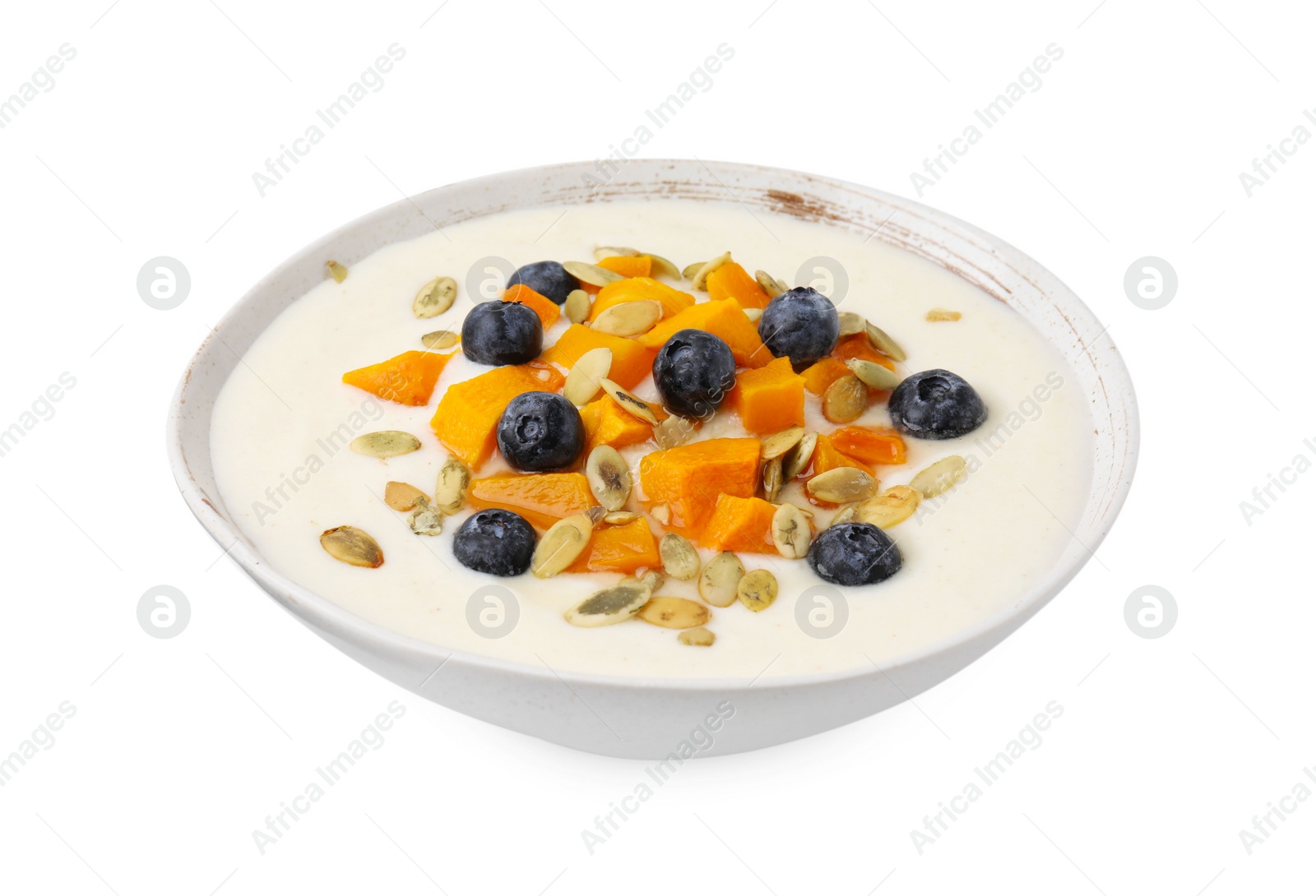 Photo of Bowl of delicious semolina pudding with blueberries, pumpkin and seeds isolated on white