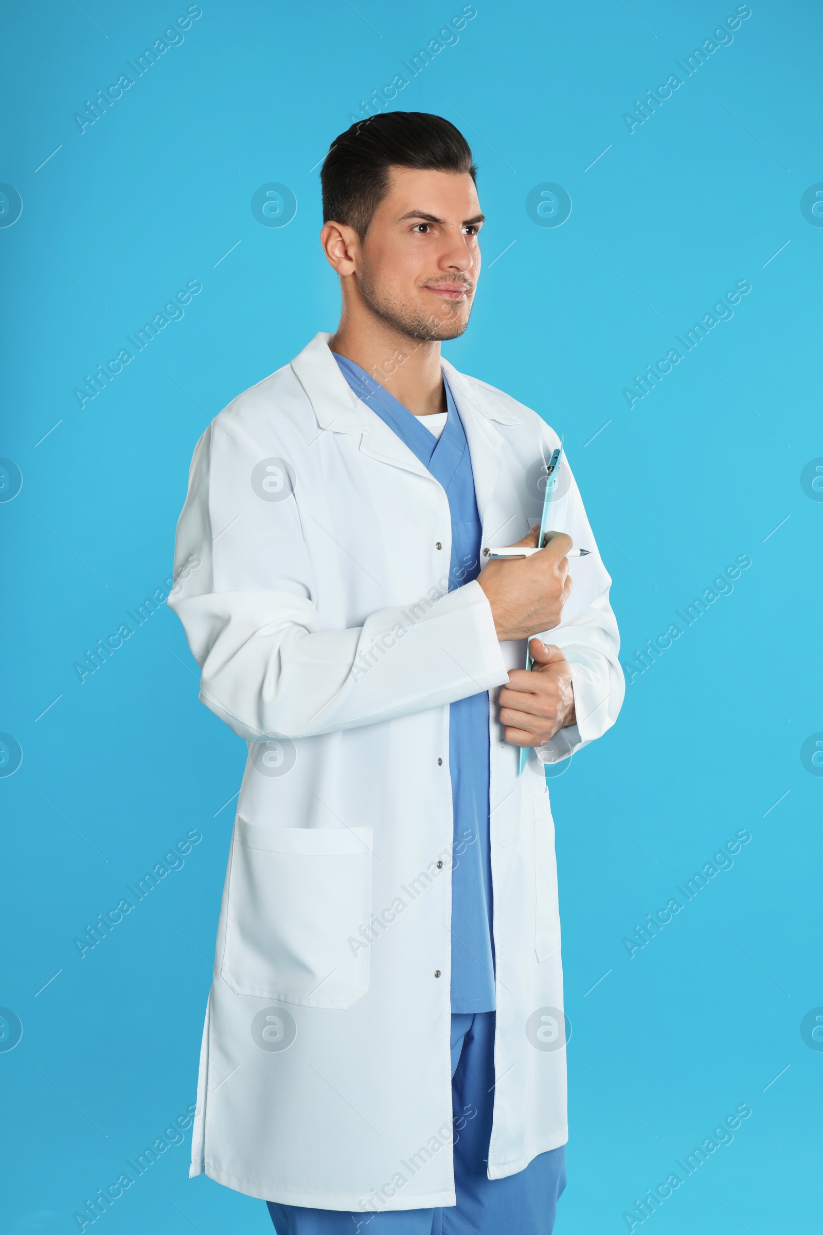 Photo of Doctor in uniform with clipboard on blue background