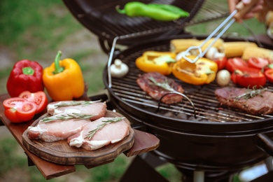 Photo of Modern barbecue grill with fresh products outdoors, closeup