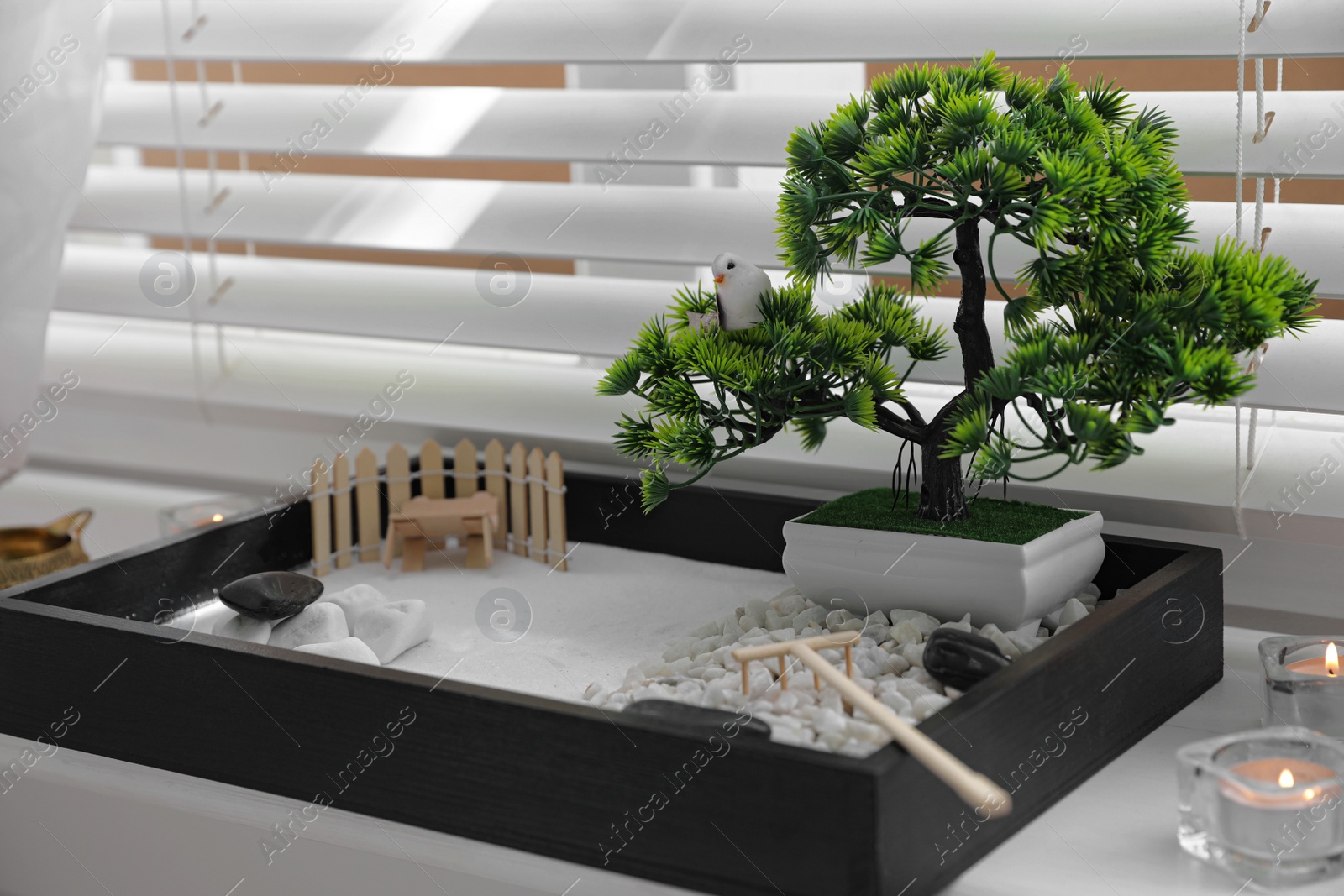 Photo of Beautiful miniature zen garden and candles on window sill