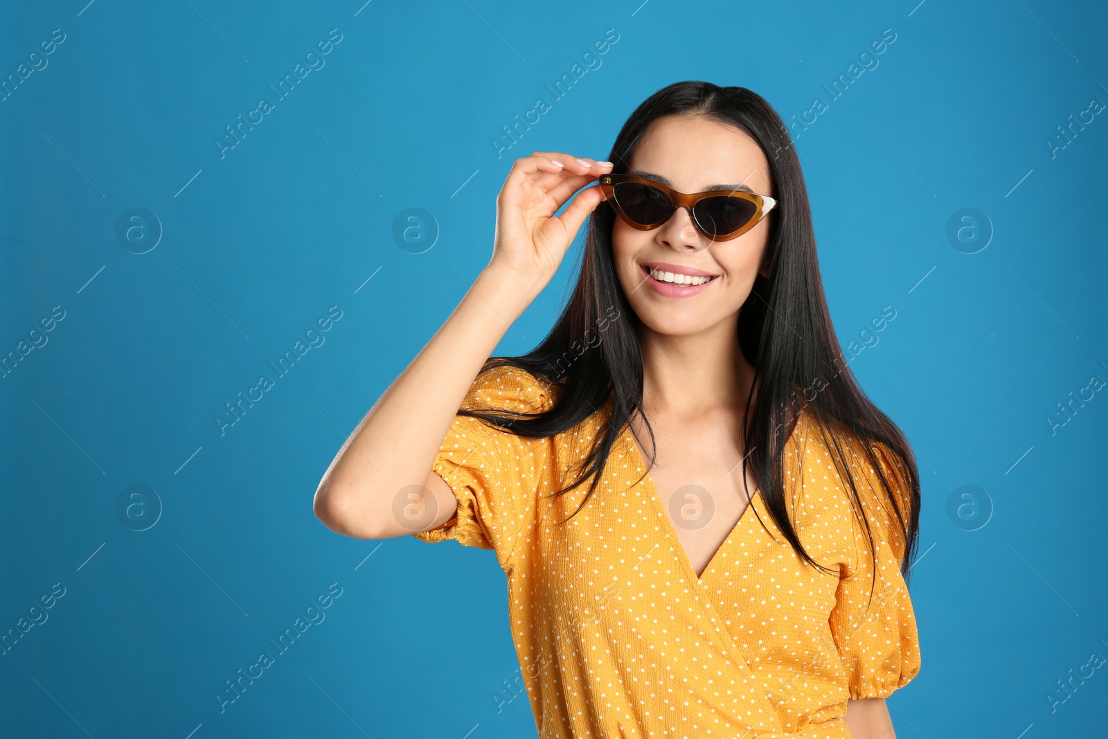Photo of Beautiful woman wearing sunglasses on blue background
