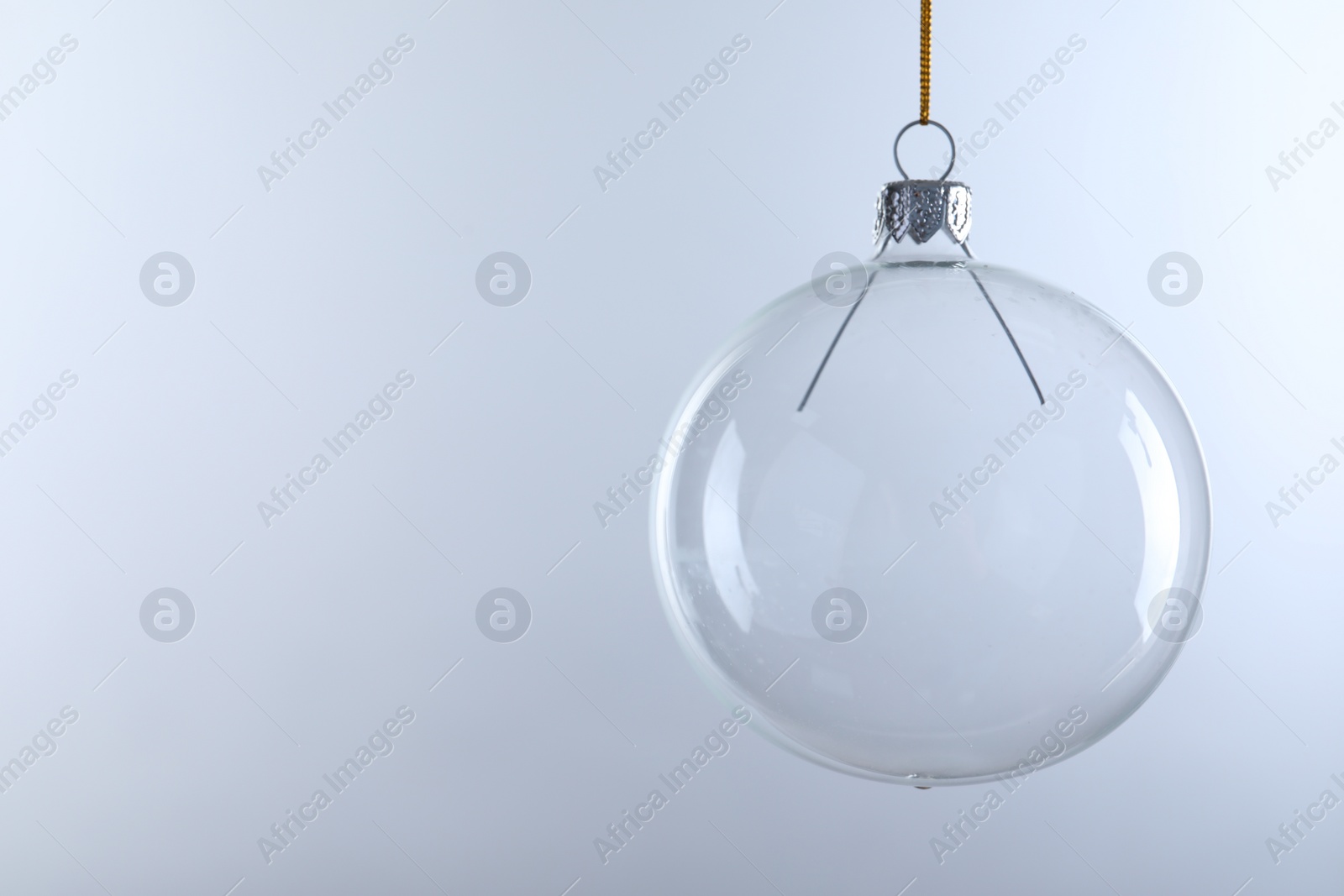 Photo of Transparent glass Christmas ball against light background. Space for text