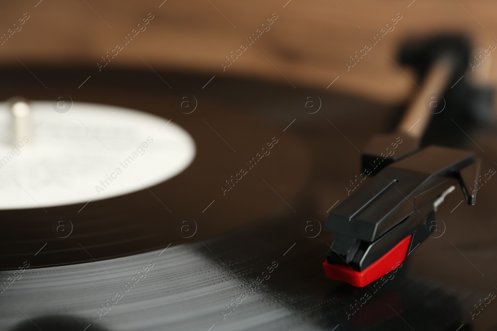 Photo of Vinyl record on turntable against blurred background, closeup