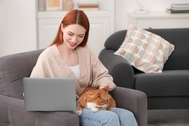 Photo of Happy woman with cat working in armchair at home, space for text