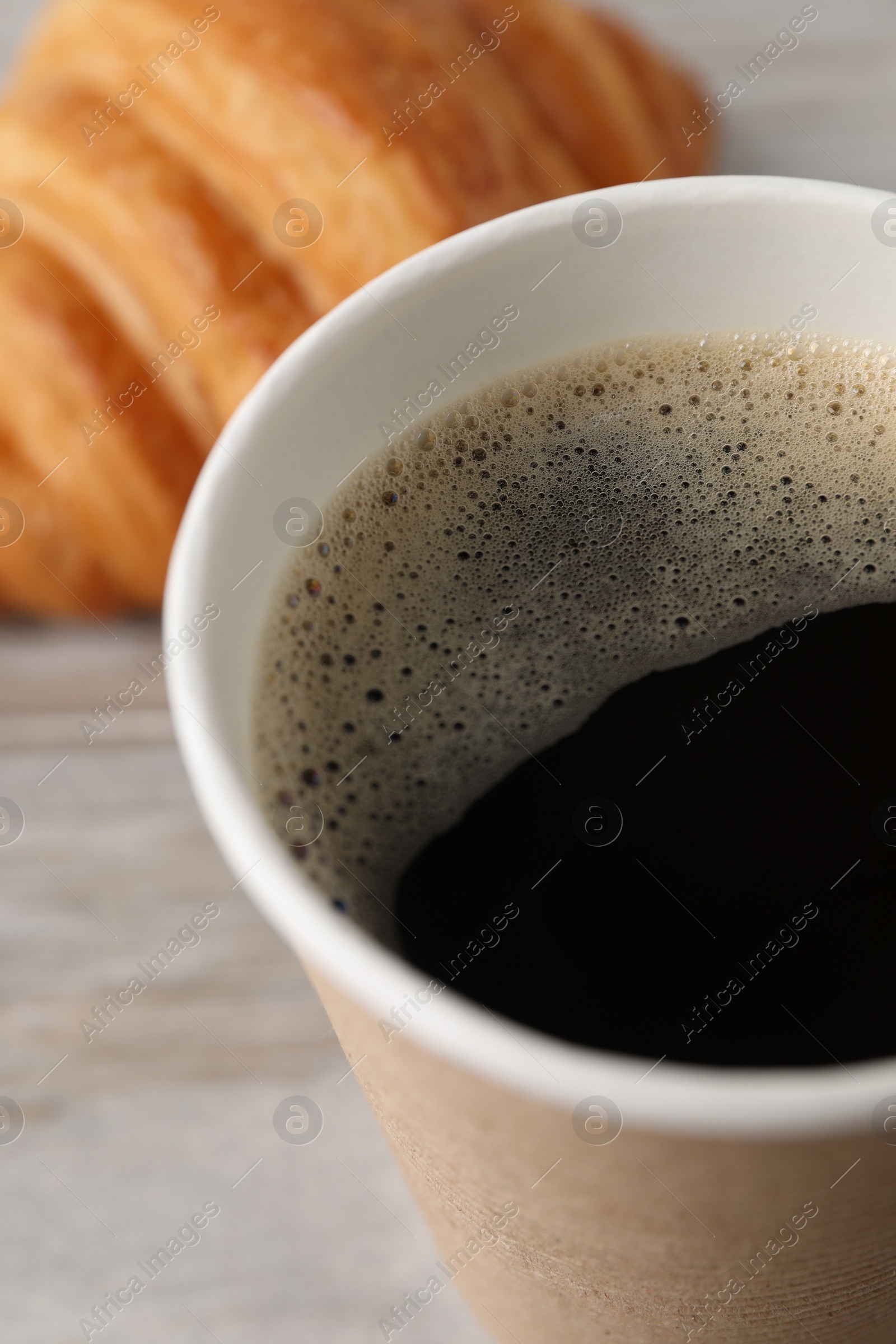 Photo of Coffee to go. Paper cup with tasty drink on table, closeup