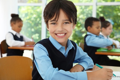 Boy wearing new school uniform in classroom